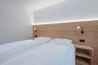 a bed with two white pillows in a bedroom at Apartments Corcela in San Vigilio Di Marebbe