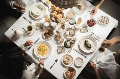a group of people sitting around a table with food at Ansitz Heufler by Norbert Niederkofler in Rasun di Sopra