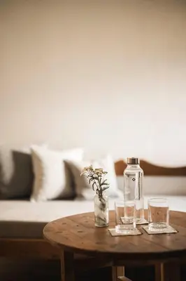 a table with two glasses and a bottle on it at Ansitz Heufler by Norbert Niederkofler in Rasun di Sopra
