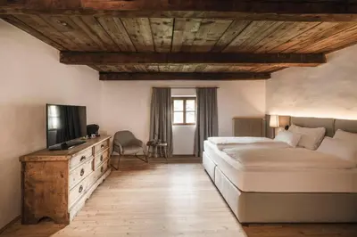 a bedroom with a bed and a television in it at Ansitz Heufler by Norbert Niederkofler in Rasun di Sopra