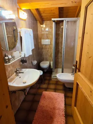 a bathroom with two sinks and a shower at Pizzeria Marmolada Camere in Sottoguda