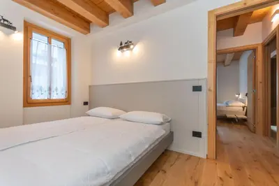a bedroom with a large bed and a window at Villa Caterina in Falcade