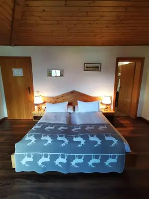 a bedroom with a bed with a blue comforter at Hotel Eden Guesthouse in Marlengo