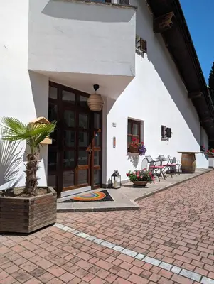 a white building with a door and a patio at Hotel Eden Guesthouse in Marlengo