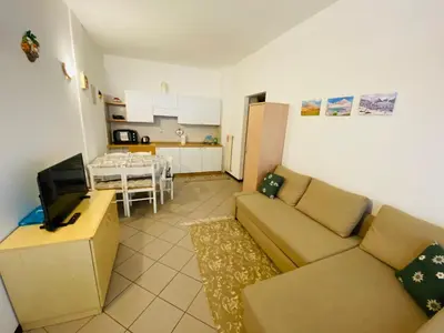 a living room with a couch and a kitchen at Bilocale Cristina Mazzin in Campestrin