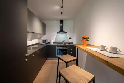 a kitchen with a counter and a wooden counter top at Casa Paolina - Alpine Stay Apartments in Tesero