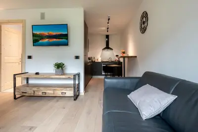 a living room with a blue couch and a table at Casa Paolina - Alpine Stay Apartments in Tesero