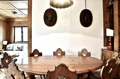 a dining room with a wooden table and chairs at Beautiful 3 bedroom flat in Cortina with car park in Cortina dʼAmpezzo