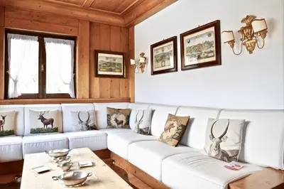 a living room with a white couch and a table at Beautiful 3 bedroom flat in Cortina with car park in Cortina dʼAmpezzo