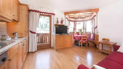 a kitchen with a living room and a dining room at Residence Carin in Selva di Val Gardena