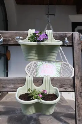 two flower pots on a bench with flowers in them at Tulpe Apartments in Vandoies di Sotto