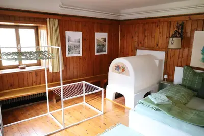 a living room with wood paneling and a couch and a chair at Tulpe Apartments in Vandoies di Sotto