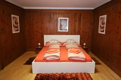 a bedroom with a bed with orange sheets and pillows at Tulpe Apartments in Vandoies di Sotto