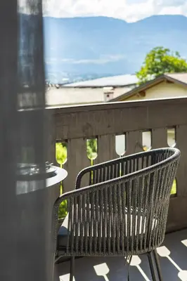 a bench sitting on top of a balcony at LUXE VISTA City Apartments Algund in Lagundo
