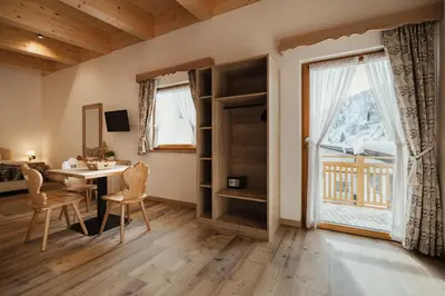 a room with a desk and a window at Hotel Monte Cherz in Arabba