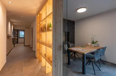 a dining room with a table and a wooden wall at Malojerhof in Lana