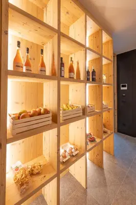 a room with wooden shelves filled with bottles and fruit at Malojerhof in Lana