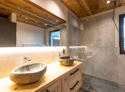 a bathroom with a stone sink on a wooden counter at Malojerhof in Lana