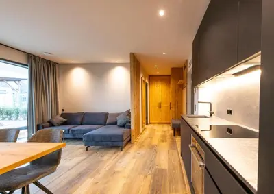 a kitchen and living room with a couch and a table at Malojerhof in Lana