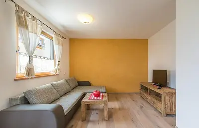 a living room with a couch and a tv at Sonngartenhof in Termeno