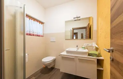 a bathroom with a sink and a toilet and a mirror at Sonngartenhof in Termeno