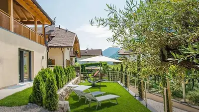 a patio with a table and chairs and an umbrella at Sonngartenhof in Termeno