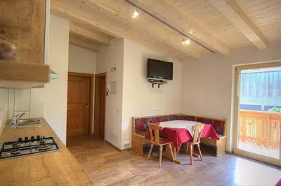 a kitchen with a table and a stove in a room at Planhof Apartments in San Martino in Badia