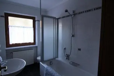 a bathroom with a shower and a tub and a sink at Planhof Apartments in San Martino in Badia