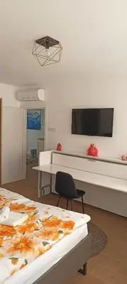 a room with two beds and a tv on the wall at Casa Giada in Bolzano