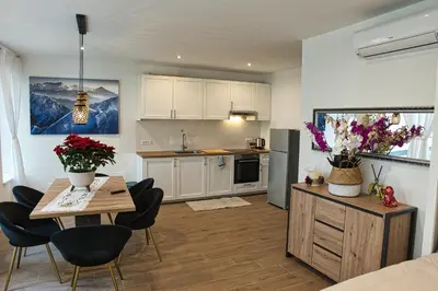 a kitchen and living room with a table and chairs at Casa Giada in Bolzano