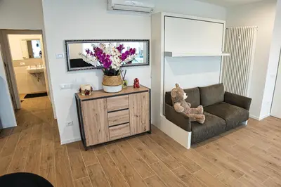 a living room with a couch and flowers on a cabinet at Casa Giada in Bolzano