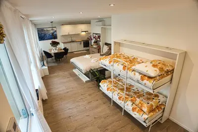 a room with two beds and a kitchen at Casa Giada in Bolzano