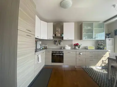 a kitchen with white cabinets and wooden floors at Alpenrösli Hafling in Avelengo