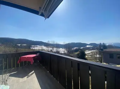 a table on the balcony of a house with snow at Alpenrösli Hafling in Avelengo