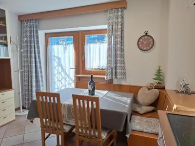 a kitchen with a table and chairs in a room at Apartments Insam in Santa Cristina in Val Gardena