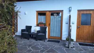 a lobby with two doors and a table and chairs at Apartments Insam in Santa Cristina in Val Gardena