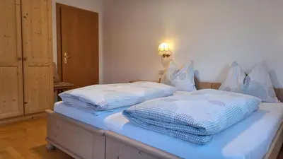 a bedroom with two beds with blue and white pillows at Apartments Insam in Santa Cristina in Val Gardena
