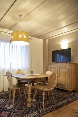 a dining room with a wooden table and chairs at Ca' del Sole in San Vito di Cadore