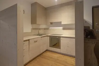 a kitchen with white cabinets and a sink at Ca' del Sole in San Vito di Cadore