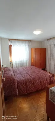 a bedroom with a large bed with a red bedspread at Panorama mozzafiato in Cortina dʼAmpezzo