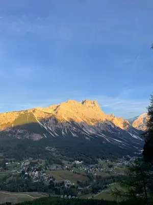 a view of a mountain range with a town and trees at Panorama mozzafiato in Cortina dʼAmpezzo