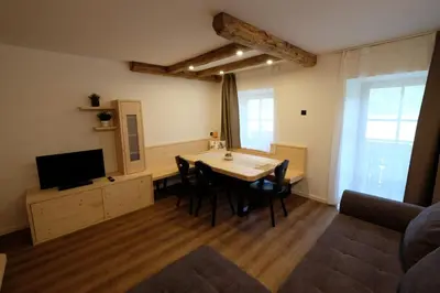 a living room with a table and chairs and a television at Gasserhof in Campo di Trens