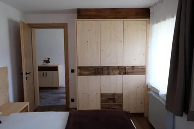 a bedroom with a wooden cabinet and a bed at Gasserhof in Campo di Trens