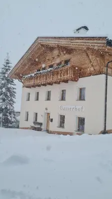 a white building with snow on the ground in front of it at Gasserhof in Campo di Trens