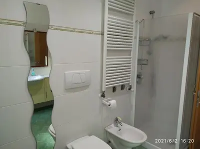 a white bathroom with a toilet and a sink at Maso de Propian in Tesero