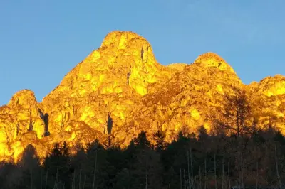 a mountain with the sun shining on it at Maso de Propian in Tesero