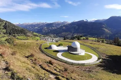 an observatory on a hill with mountains in the background at Maso de Propian in Tesero