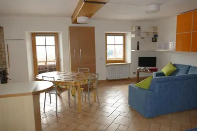 a living room with a table and a blue couch at Maso de Propian in Tesero