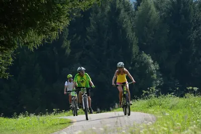 three people riding bikes down a dirt road at Il Nido del Picchio in Anterivo