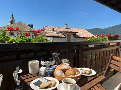 a table with plates of food on a balcony at Il Nido del Picchio in Anterivo